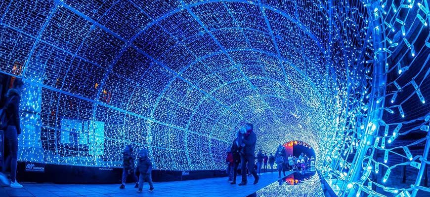 Tunnel van lichtjes in Norwich waar mensen doorheen wandelen