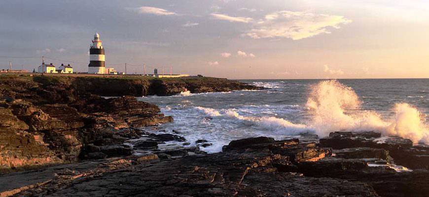 Hook Head vuurtoren en rotsen langs zee